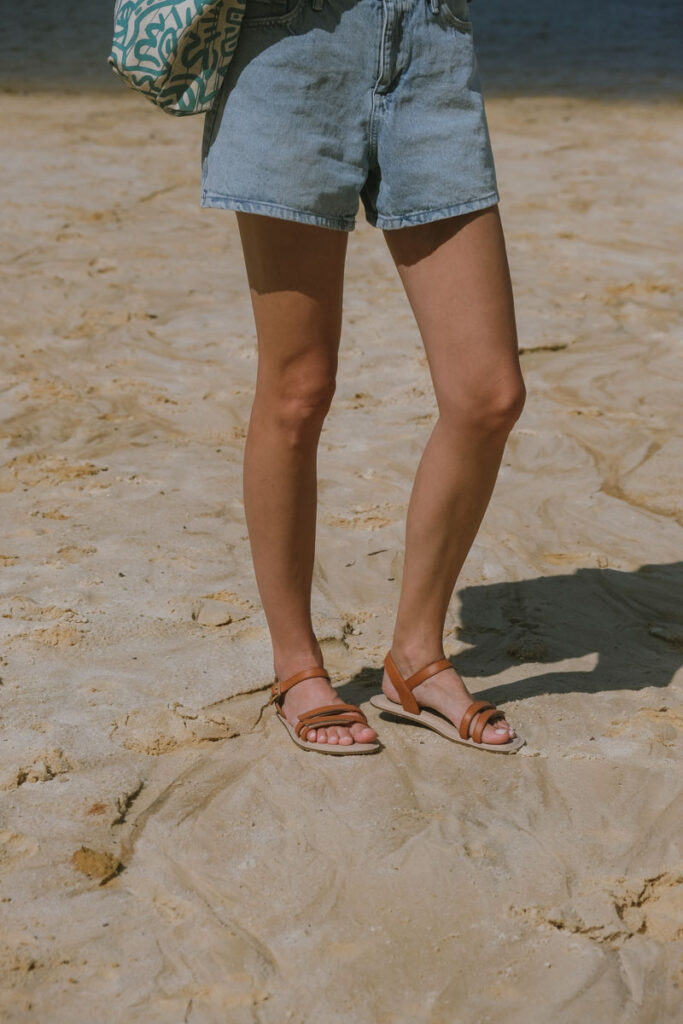 Kelly wearing the Be Lenka Summer barefoot sandals standing on the sand